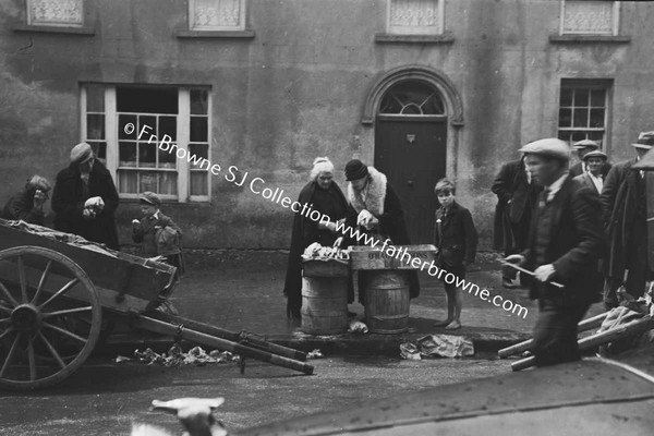 FISHMONGER IN STREET WITH HAND CART